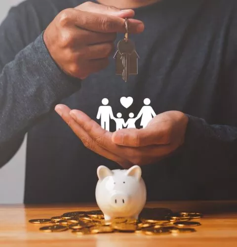 Tirelire avec pièces et famille. Représentation de la donation immobilière en famille