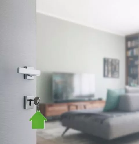 Porte ouverte avec clés entrant dans un appartement meublé