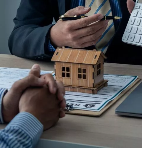 Les agents commerciaux et les nouveaux propriétaires signent un contrat d'achat ou de location immobilière sur la table.