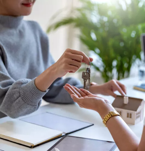 Agent immobilier donne sa clé à un nouveau locataire.