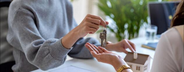 Agent immobilier donne sa clé à un nouveau locataire.