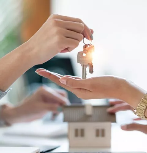 Remise des clés d’un logement entre une agente immobilière et une acheteuse.