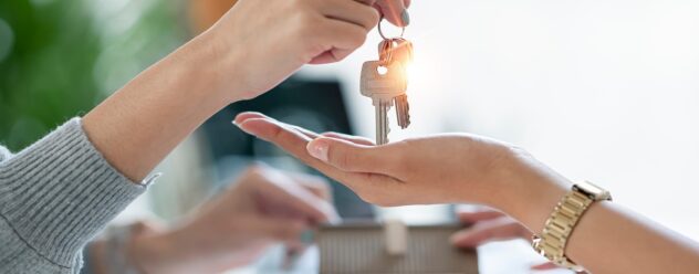 Remise des clés d’un logement entre une agente immobilière et une acheteuse.
